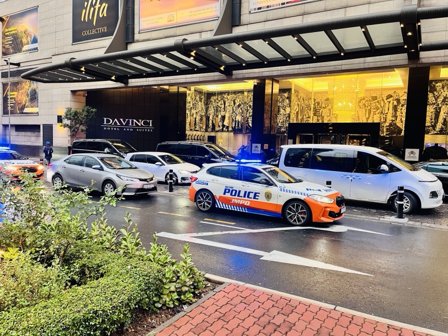 Luxury shuttle vehicles with police escort driving in a city street in sandton Johannesburg