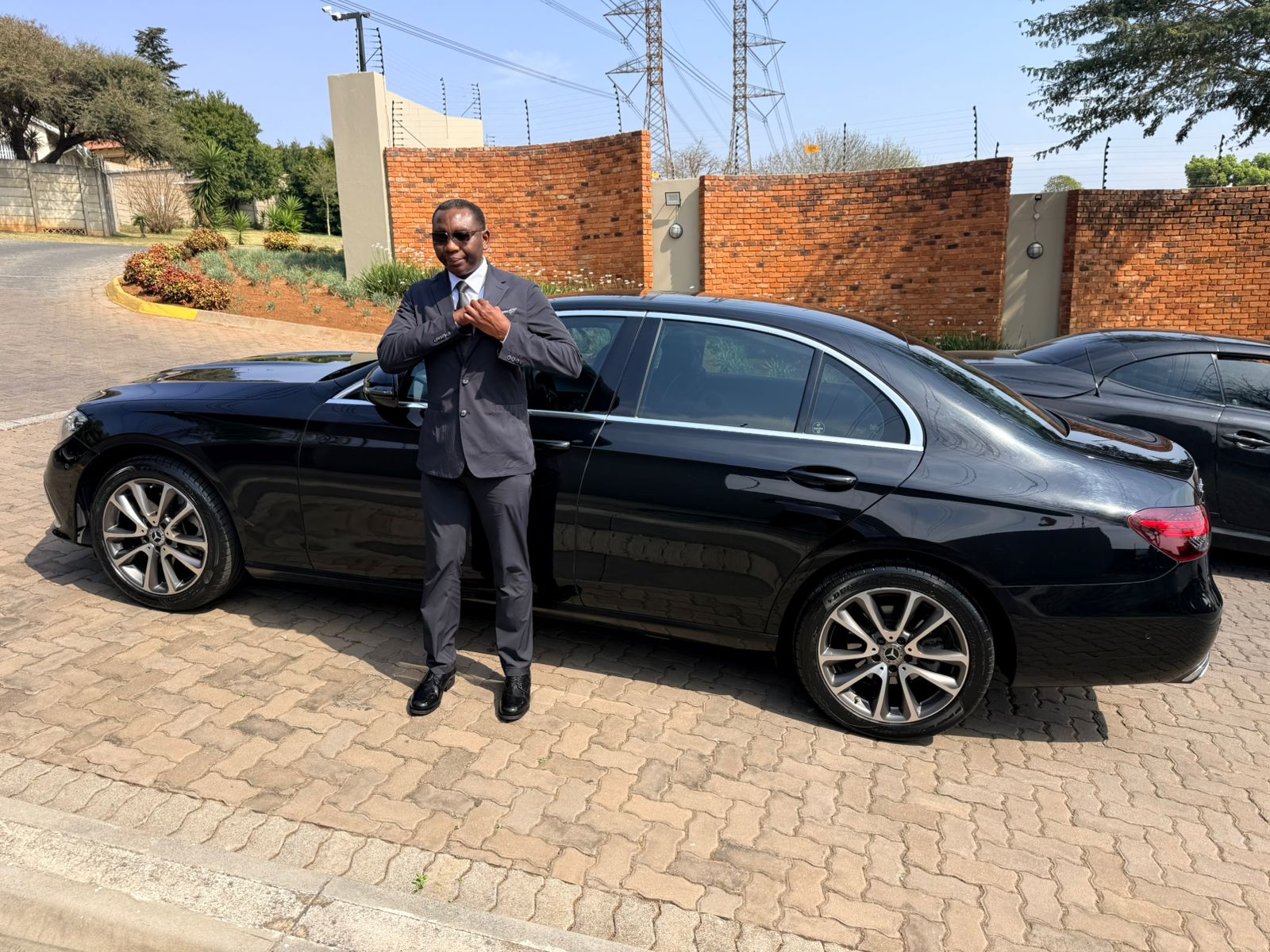 A2B Shuttle VIP chauffeur Patrick standing beside the Mercedes-Benz E-Class